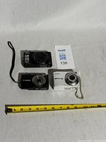 All three cameras with tape measure for scale