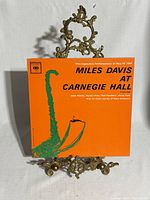 Front cover of Miles Davis At Carnegie Hall LP on stand