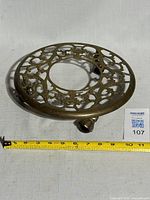 Top view showing ornate brass scrollwork and measuring tape for size