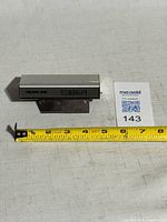 Front view showing LCD display reading 6:55 and TALKING TIME logo with measuring tape for scale