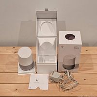 All contents laid out: smart speaker, power adapter, quick start guide, open box with inserts