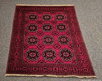 Full view of red Bokhara rug showing field and borders
