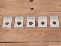 Front view of all five INB-slabbed coins