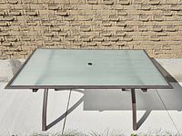 Full view of glass patio table top showing umbrella hole and rectangular shape