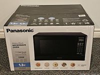 Retail box showing Panasonic matte black microwave NN-SU64LB, specs and capacity