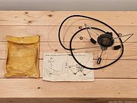 Stove assembly, pouch, and instruction sheet laid out on wooden surface