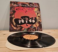 Vinyl record on paper inner sleeve in front of jacket showing label and cover art