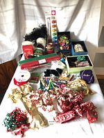 Craft supplies spread on table showing ribbons, mesh, faux fur, stamps, organizer boxes, sealed kits and storage bin