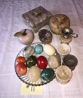 Group shot of eggs, boxes, apple, urn and dish