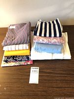 Stack of nine folded fabric pieces showing variety of patterns and colors