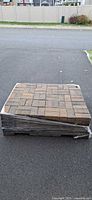Full pallet of stacked interlocking pavers wrapped in plastic