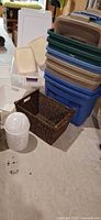 Stack of plastic storage totes with assorted lids