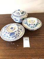 Three covered porcelain bowls displayed on tabletop