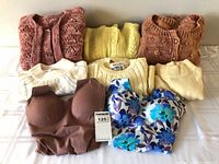 Group shot of two tank tops and six sweaters/cardigans