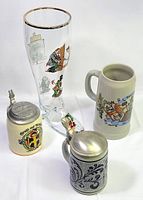 Group shot of four drinking vessels: three steins and glass boot