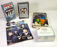 All five Beatles items grouped: sealed Help! VHS, sealed A Hard Day’s Night VHS, Guitar Player August 2004 magazine, Hunter Davies biography book, sealed Beatles Trivia Game box