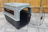 Disassembled crate showing grey top, black base, and open metal door