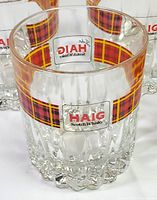 Close-up of single glass showing logo, tartan band and glass pattern