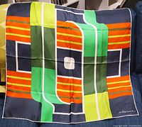 Full view of silk scarf showing geometric multicolour design