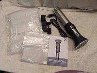 all components laid out: circulator, clamp, two bag sets, booklet