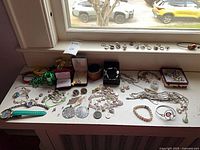 Wide shot of entire lot spread on table showing watches, bracelets, necklaces, rings, beads
