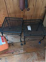 Both metal patio tables side by side on wooden floor