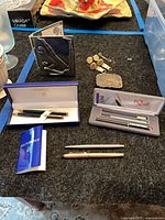 Group shot showing all pens, boxed sets, cufflinks, tie bar, belt buckle and Carrol Boyes piece