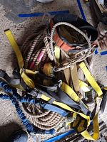 Full view of coiled rope with assorted straps and hooks