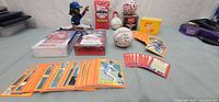 Overall view of trading cards, sealed boxes, bobblehead, desk sculpture and baseballs