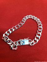 Full view of bracelet laid out showing curb links and clasp