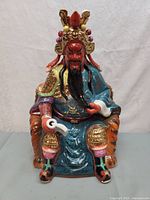 front view of glazed porcelain Guan Yu statue on throne