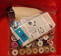 Top view showing bagged instructions, tray of assorted thread spools