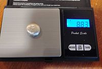 Round silver blob on scale reading 8.83 g