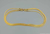 Entire necklace laid flat showing three strands