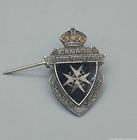 Front view of sterling silver Order of St John service pin showing Canada bar, dates, black enamel shield, Maltese cross