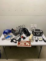 Entire lot arranged on table showing all electronics, sign and accessories