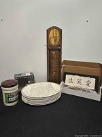 All items grouped: plate stack, coffee jar, boxed coffee set, wall plaque in box, wooden note holder