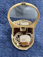 Shaver inside open clamshell case showing mirror and cord