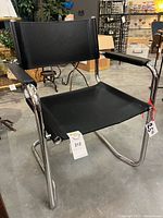 Front angled view of black cantilever armchair showing overall design and chrome base