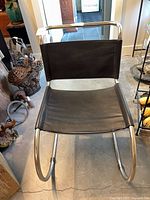 Front view of one chair showing chrome frame and black sling upholstery