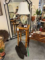 Full view of lamp on bamboo stand with two wood platters leaning against stand
