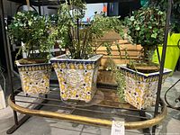 Three ceramic planters with lemon design and faux plants on shelving
