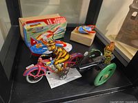 All four tin toys in display: rocket boat with box, SPACE-2 rocket, motorcycle, cannon