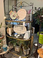 Front view of baker's rack with three shelves and decorative metalwork