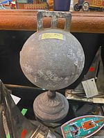 Full view of spherical cast iron buoy on stand