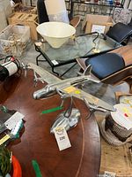 Oblique view of polished metal airplane sculpture on wooden table