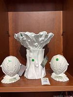 Front view of bowl on base flanked by both shell vases