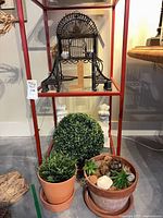 Overall lot showing bird cage on shelf, potted plants and column pedestals