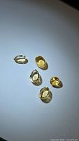 Five golden citrine cabochons on white background