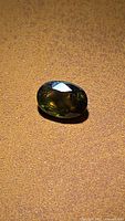 Front angled view of oval sapphire showing multicolored facets